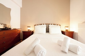 A hotel room with a large bed, two bedside tables with lamps, a dresser, and a mirror on the wall. - Comfy stay 2br flat 1gbps 4 min walk from metro (Athina)