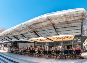 A modern building with a curved roof and outdoor seating area. - Le sétois 2, intimiste et cosy (Sète)