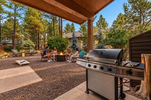 Eine Außenpatio mit Grill, Sitzgelegenheit und einem Feuerkorb.