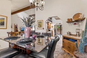 A modern kitchen with a central island, dining chairs, and a chandelier. - NEW! | Rustic Woodland Retreat | Pets | Fireplace (Flagstaff)