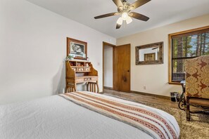 A bedroom with a bed, a desk, a chair, a ceiling fan, and a window with blinds. - NEW! | Rustic Woodland Retreat | Pets | Fireplace (Flagstaff)