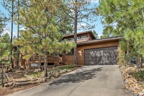 A modern two-story house with a garage, surrounded by pine trees. - NEW! | Rustic Woodland Retreat | Pets | Fireplace (Flagstaff)