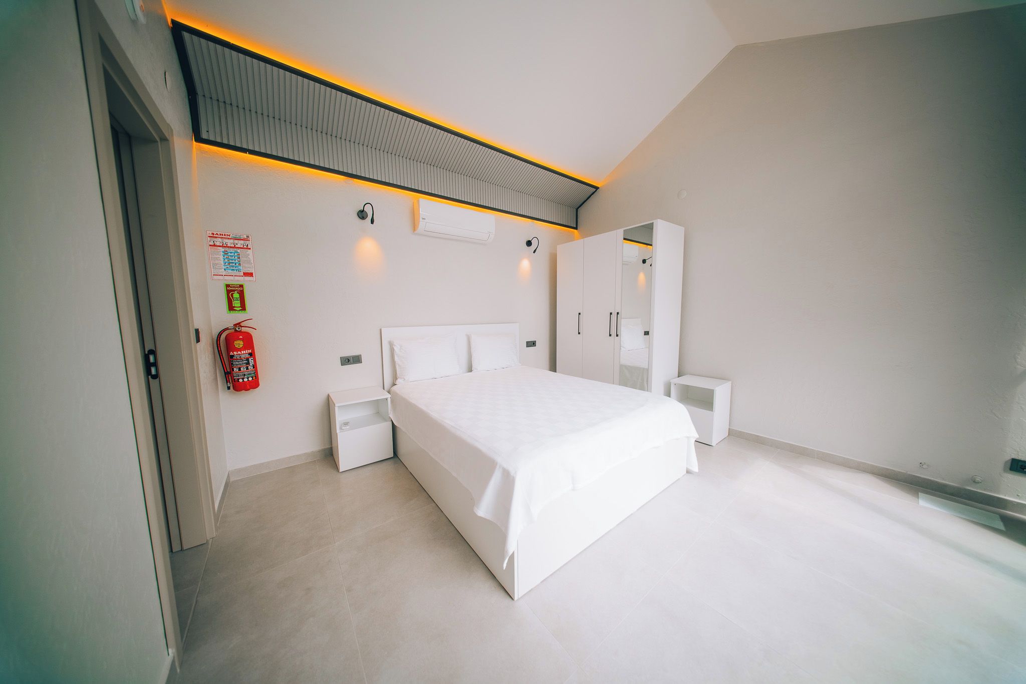 Una camera da letto moderna con un letto grande, comodini, un armadio e una lampada a soffitto.