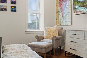 A room with a window, a chair with a fluffy pillow, a bed, and a dresser. - Spacious 4BR Home with Private Backyard Near Rittenhouse (Philadelphia)