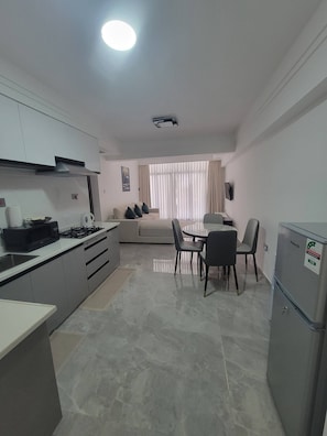 Una cucina moderna con zona pranzo, divano e TV.