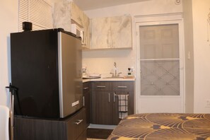 A compact kitchen with a refrigerator, a microwave, and a sink. - Segovia Room—Near the Airport (Carolina)