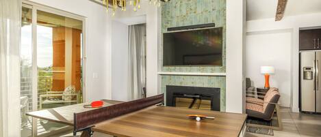 A modern living room with a dining table, sofa, and TV.