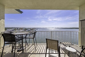 Ein Balkon mit Blick auf ein Gewässer, einem Tisch und Stühlen.