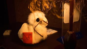 A plush toy with a red pouch sitting on a table.