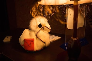 A plush toy with a red pouch sitting on a table. - Lavitor hotel (Bishkek)