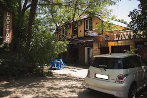 A building with a sign that reads 'BAR LAVITORS' and a parked car in front. - Lavitor hotel (Bishkek)