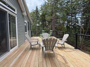 A deck with wooden flooring and two Adirondack chairs. - New 3BR House in Southwest Harbor! [Eagle`s Ledge] (Southwest Harbor)