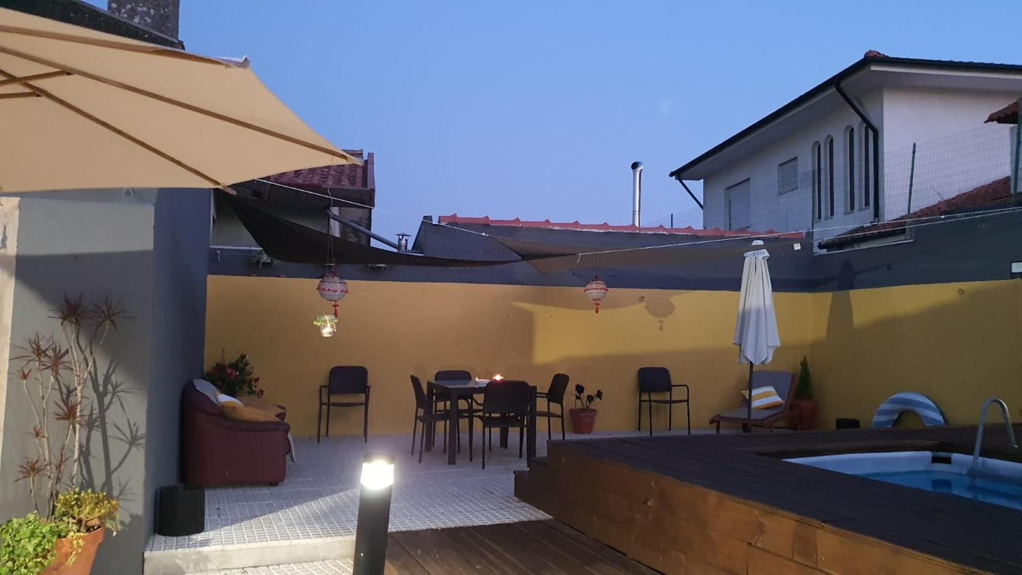 Un espace extérieur aménagé avec une terrasse, une piscine, des sièges et une partie abritée.