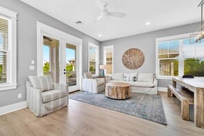 Un salón espacioso con sofá, sillones, una mesa de centro y una zona de comedor con un banco.