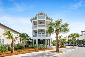 A multi-story building with balconies, surrounded by palm trees and a clear sky. - Palms by the Sea (Panama City Beach)
