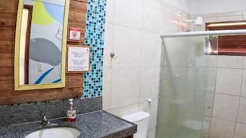 Un baño con lavamanos de granito, inodoro y cabina de ducha de vidrio.