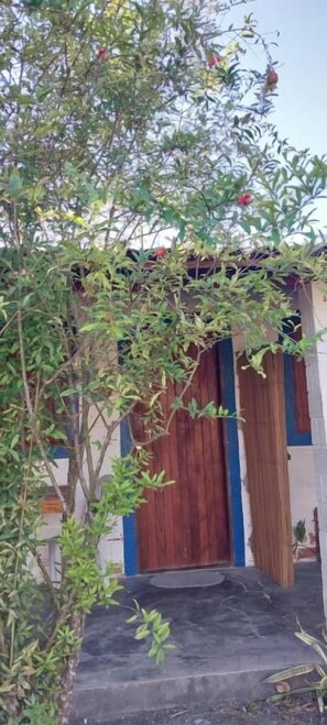 A building with a wooden door and steps leading to a porch.