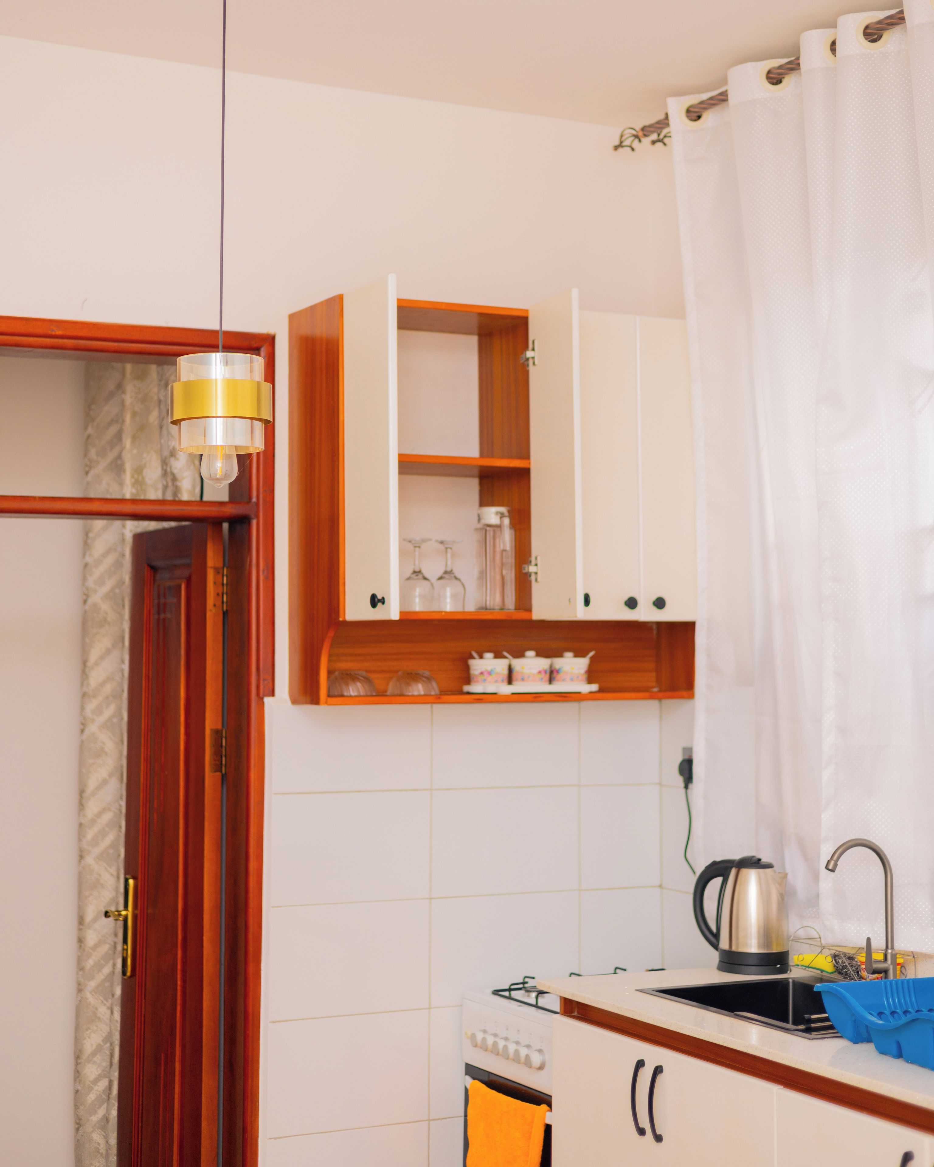 Una cucina con fornello, lavello e mobili.