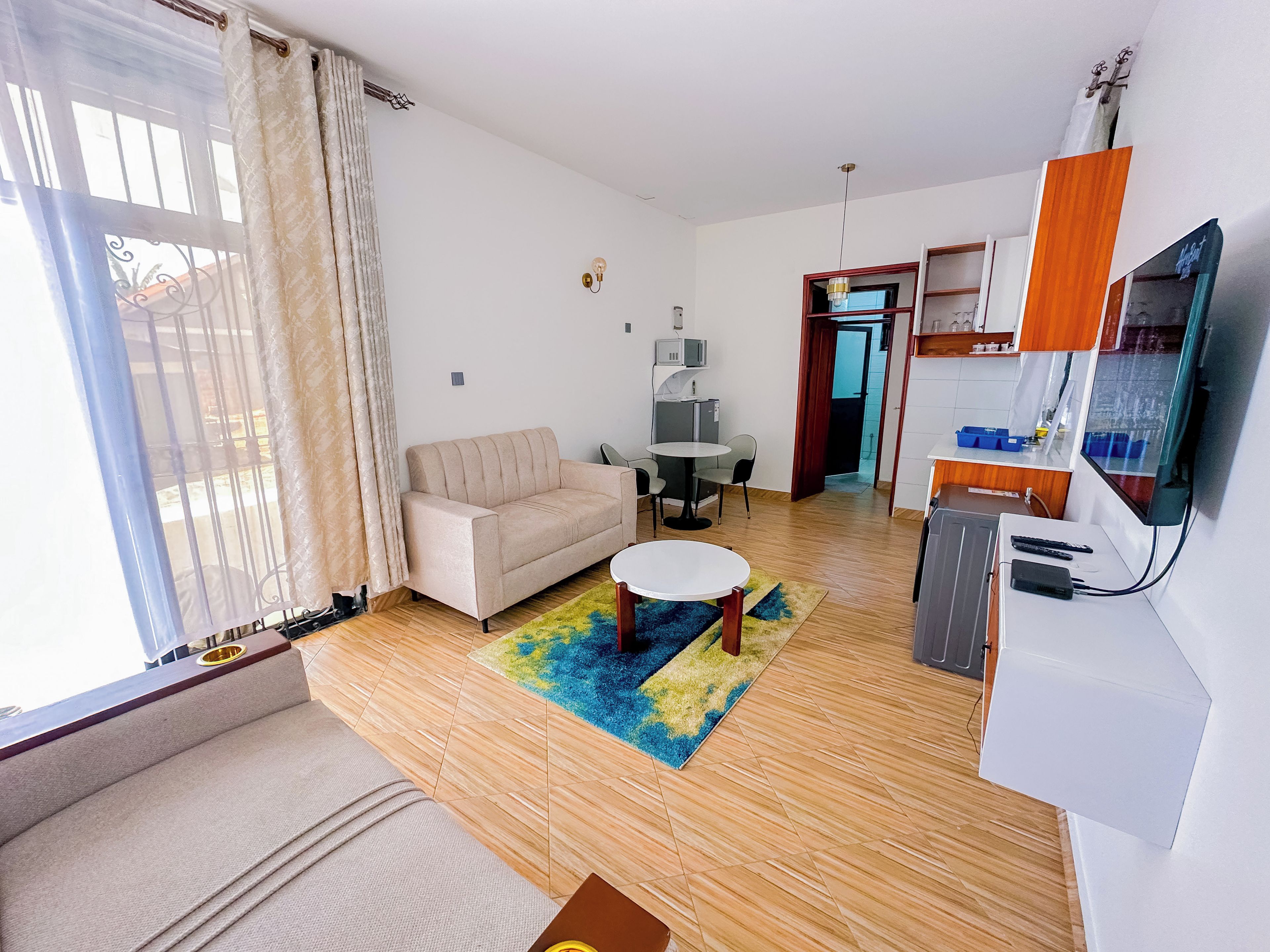 A living room with a sofa, a small round table, and a TV.