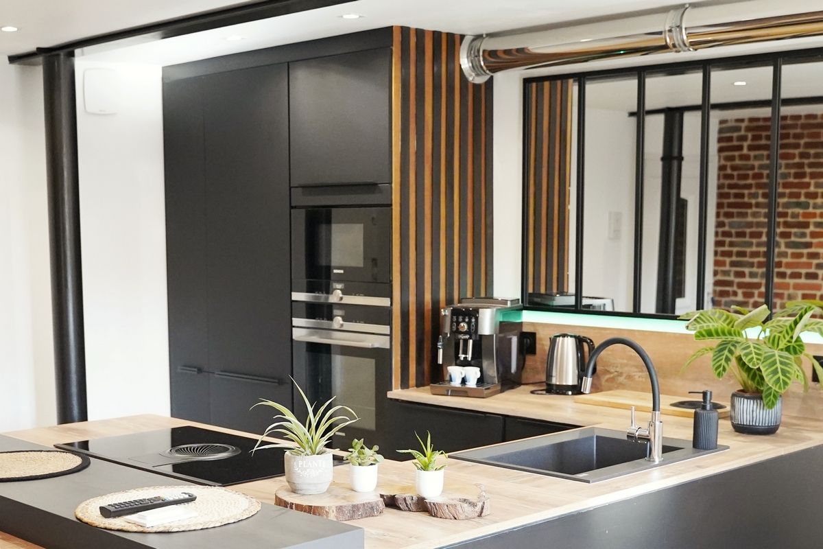A modern kitchen with a built-in oven, a coffee machine, and a sink.