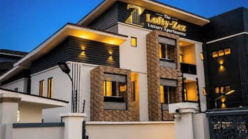 Un edificio moderno a due piani con un cartello che riporta 'The Lofty-ZeZ Luxury Apartments'.