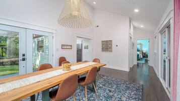 A modern dining area with a wooden table, brown chairs, and a patterned rug.