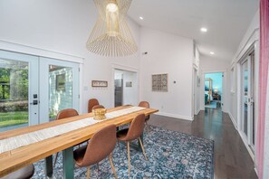 A modern dining area with a wooden table, brown chairs, and a patterned rug. - Single Story Retreat with Pavilion (Chapel Hill)