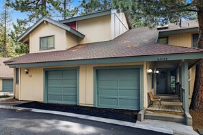 A two-story house with a garage, a porch with a bench, and a visible address number. - Powder & Putt Condo#2658 (Big Bear Lake)