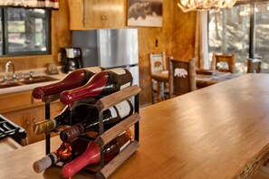 Estante de madeira com várias garrafas de vinho em uma cozinha.