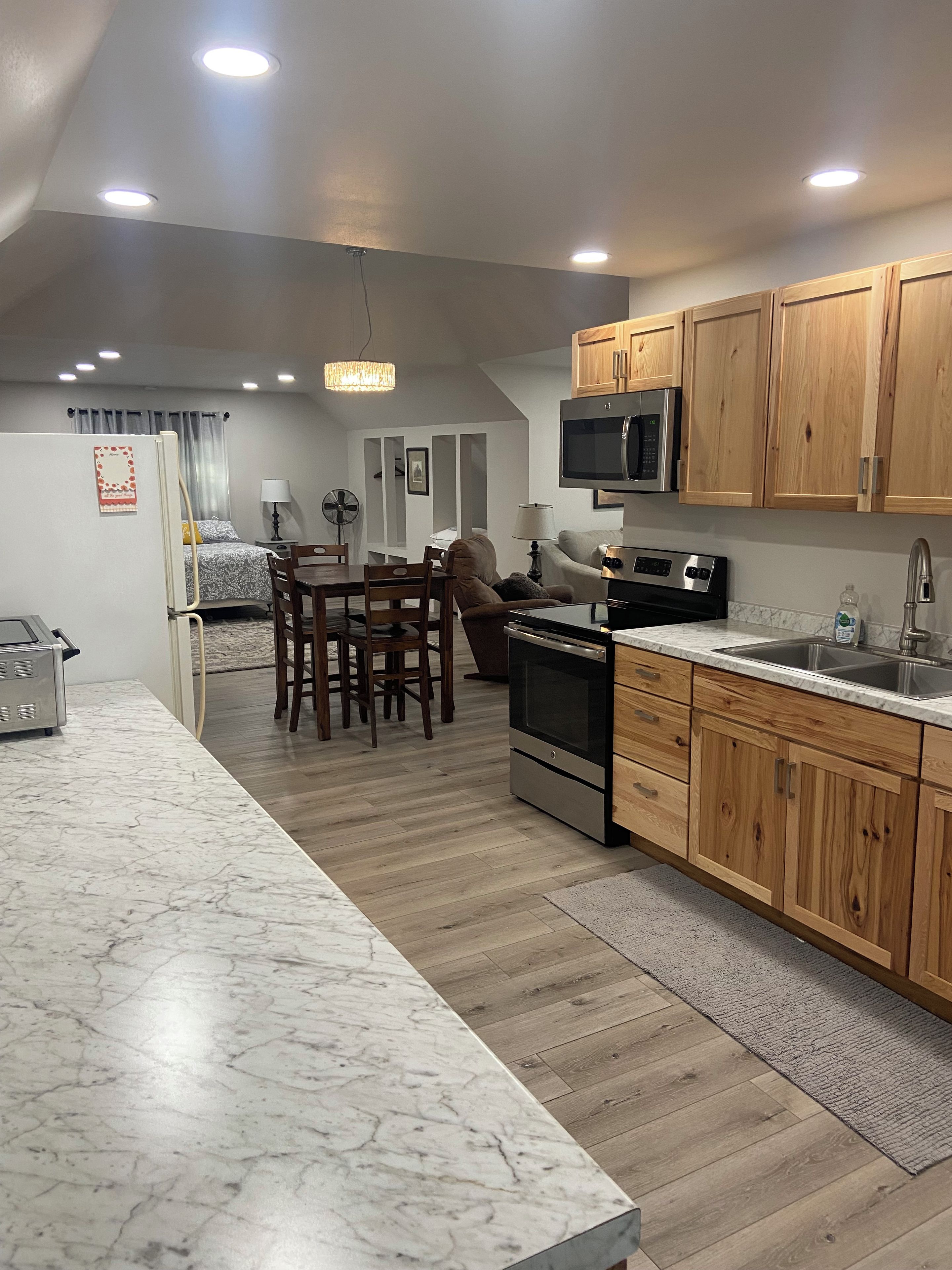 Una cocina moderna con armarios de madera, un microondas integrado y una isla grande con pileta.
