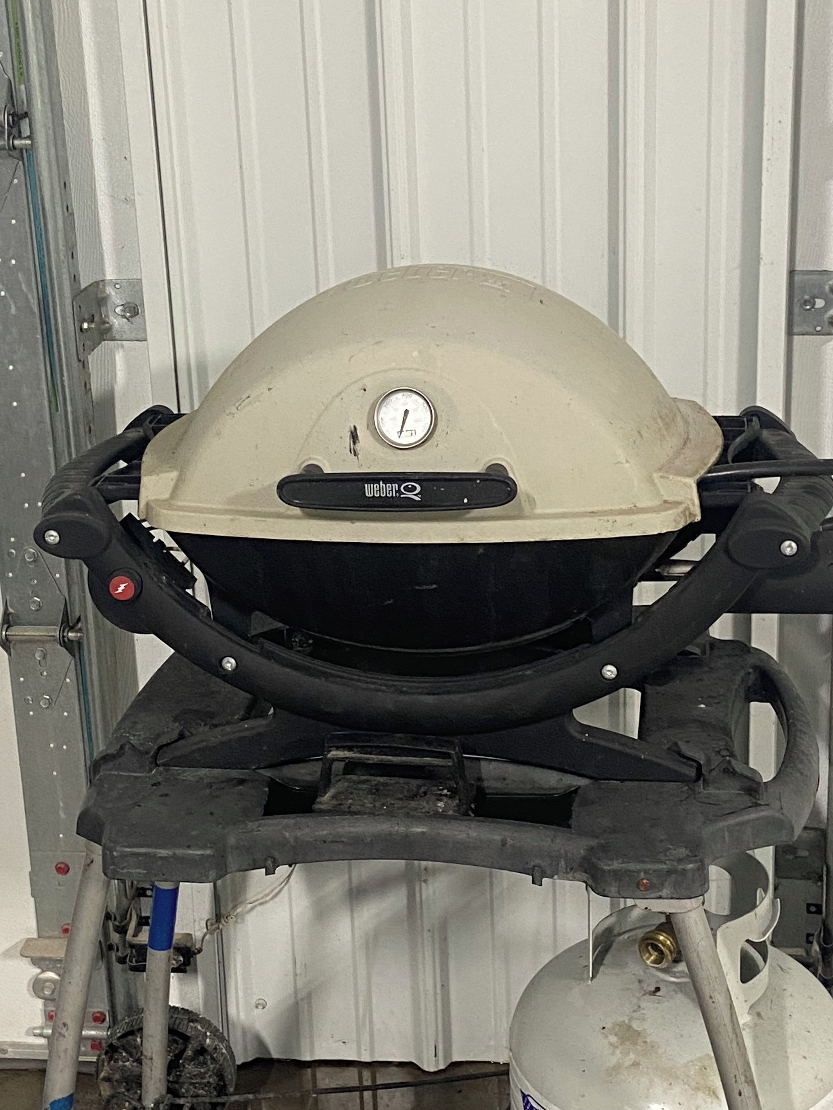 Uma motocicleta com carenagem bege e o logo Weber visível, apoiada em um suporte com um tanque de combustível embaixo.