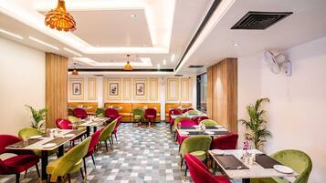 A restaurant with checkered flooring, multiple tables with chairs, and pendant lighting.