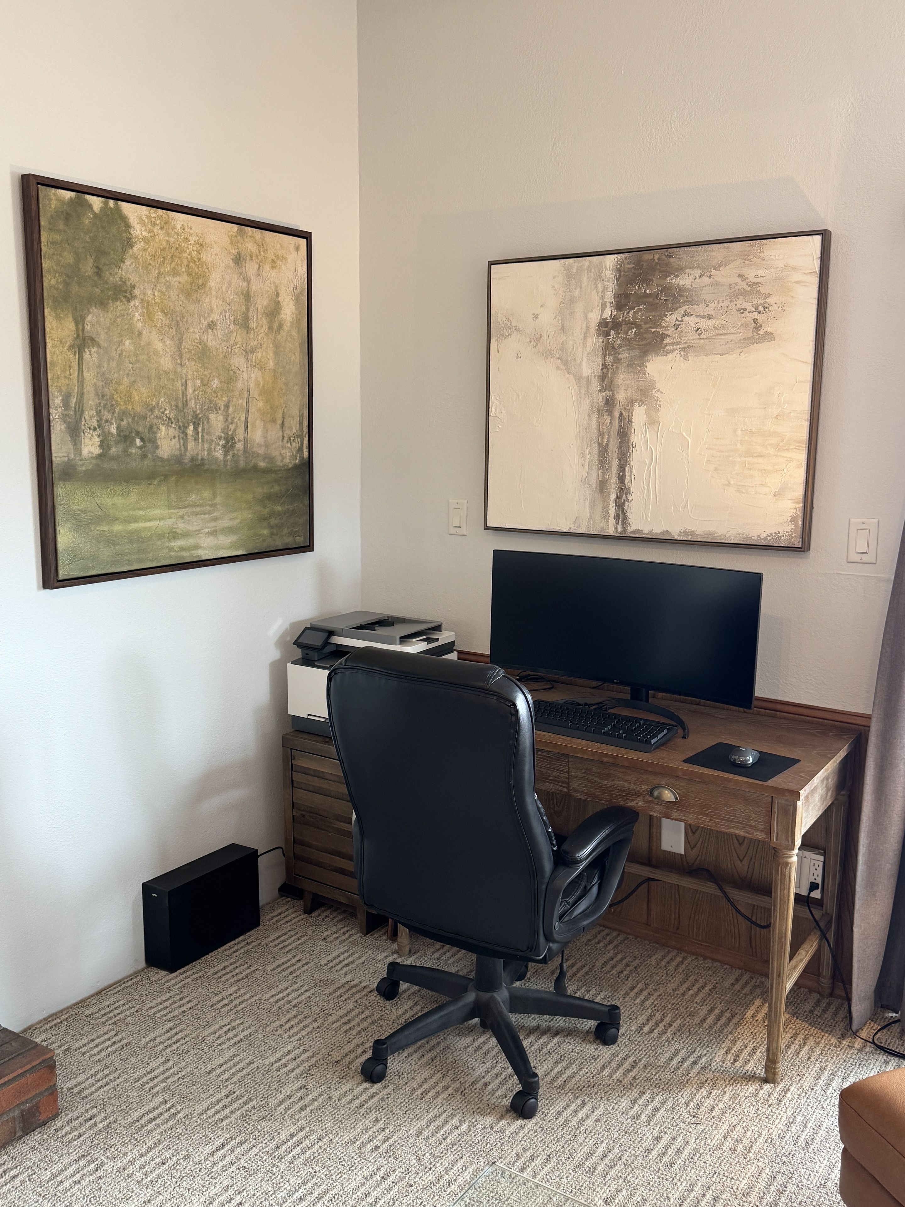 Dedicated workspace with desk, monitor, and stylish art for productive stays