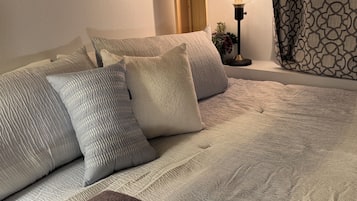 Cozy neutral bedroom with soft linens and warm bedside lighting