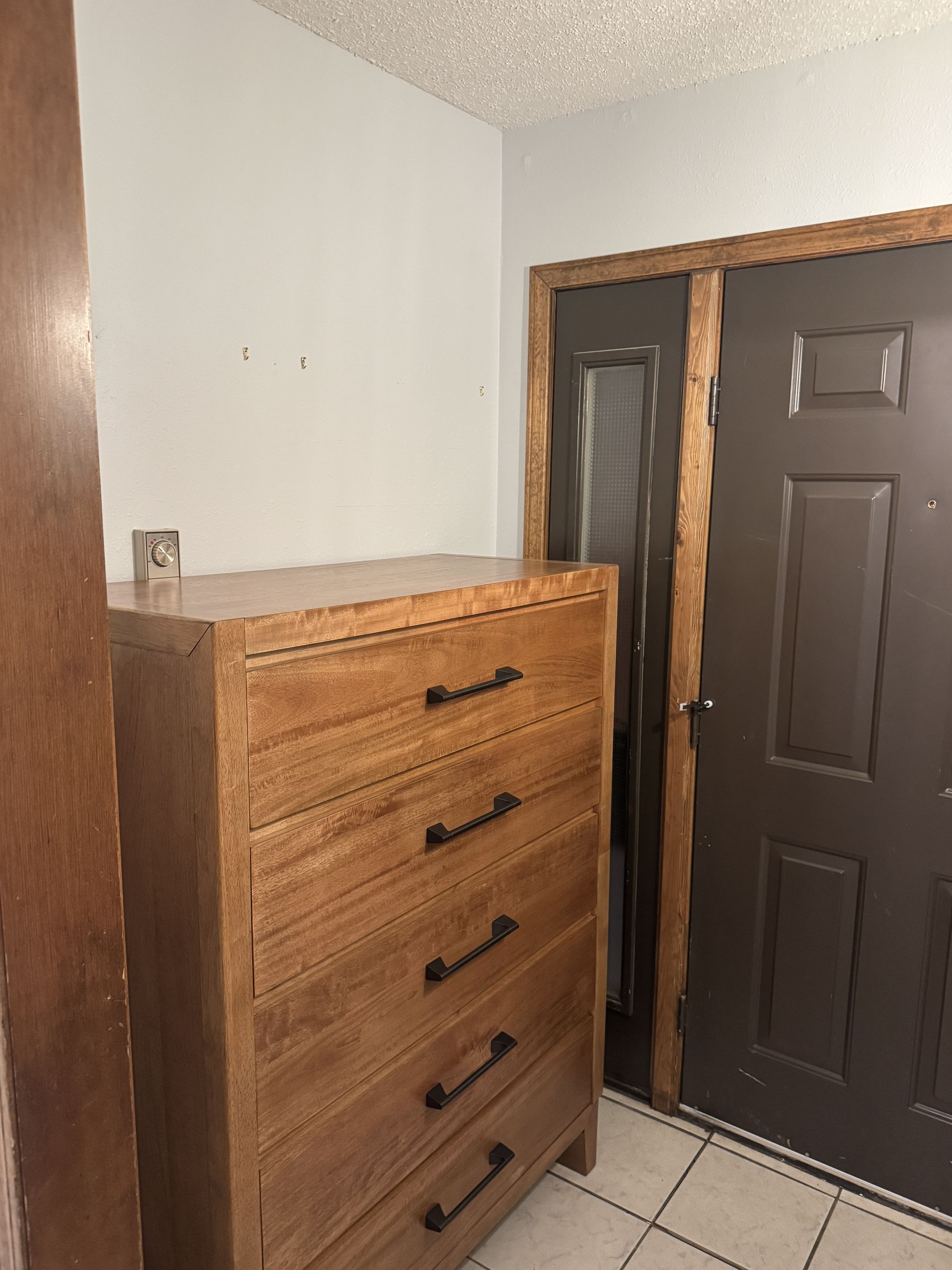 Welcoming entryway with wood storage cabinet and easy-care tile flooring