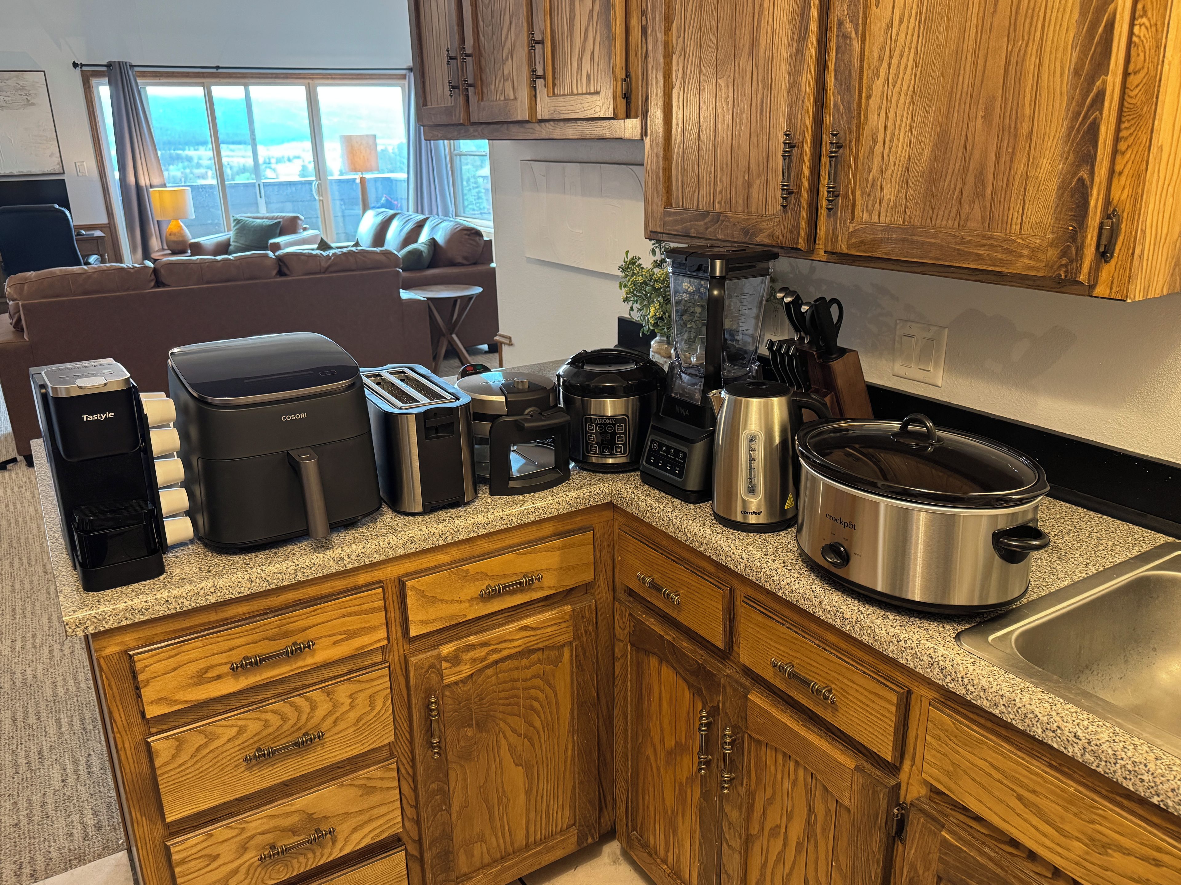 A kitchen with wooden cabinets, a coffee maker, a toaster, and a slow cooker.