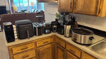 A kitchen with wooden cabinets, a coffee maker, a toaster, and a slow cooker.