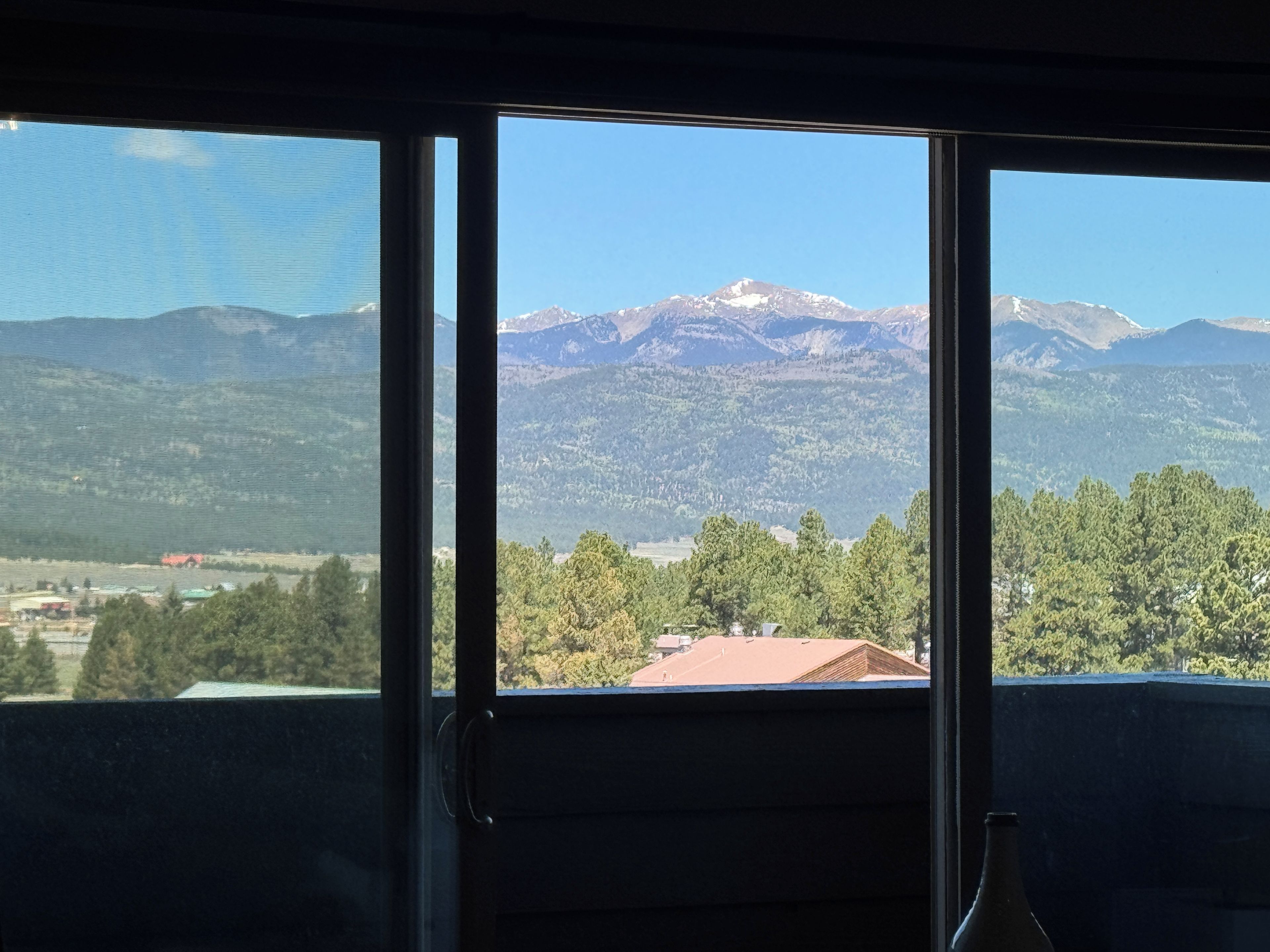 A room with a view of a mountainous landscape through a window.