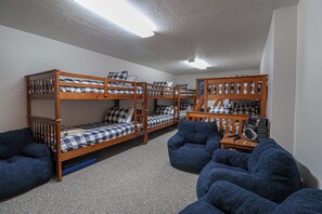 A dormitory room with bunk beds, a desk, and a chair. - Willowsprings Ranch Lodge, Sleeps 24 + Pool (Ririe)