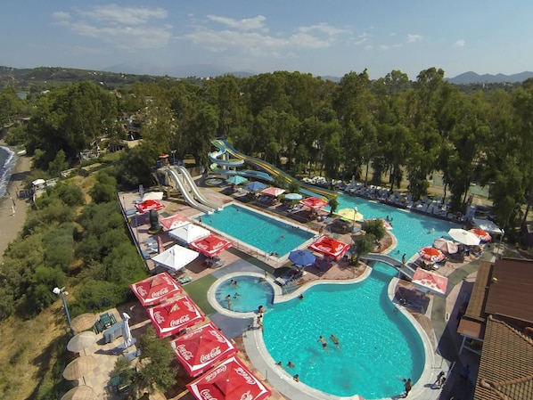 A resort with multiple swimming pools, a water slide, and beach areas.