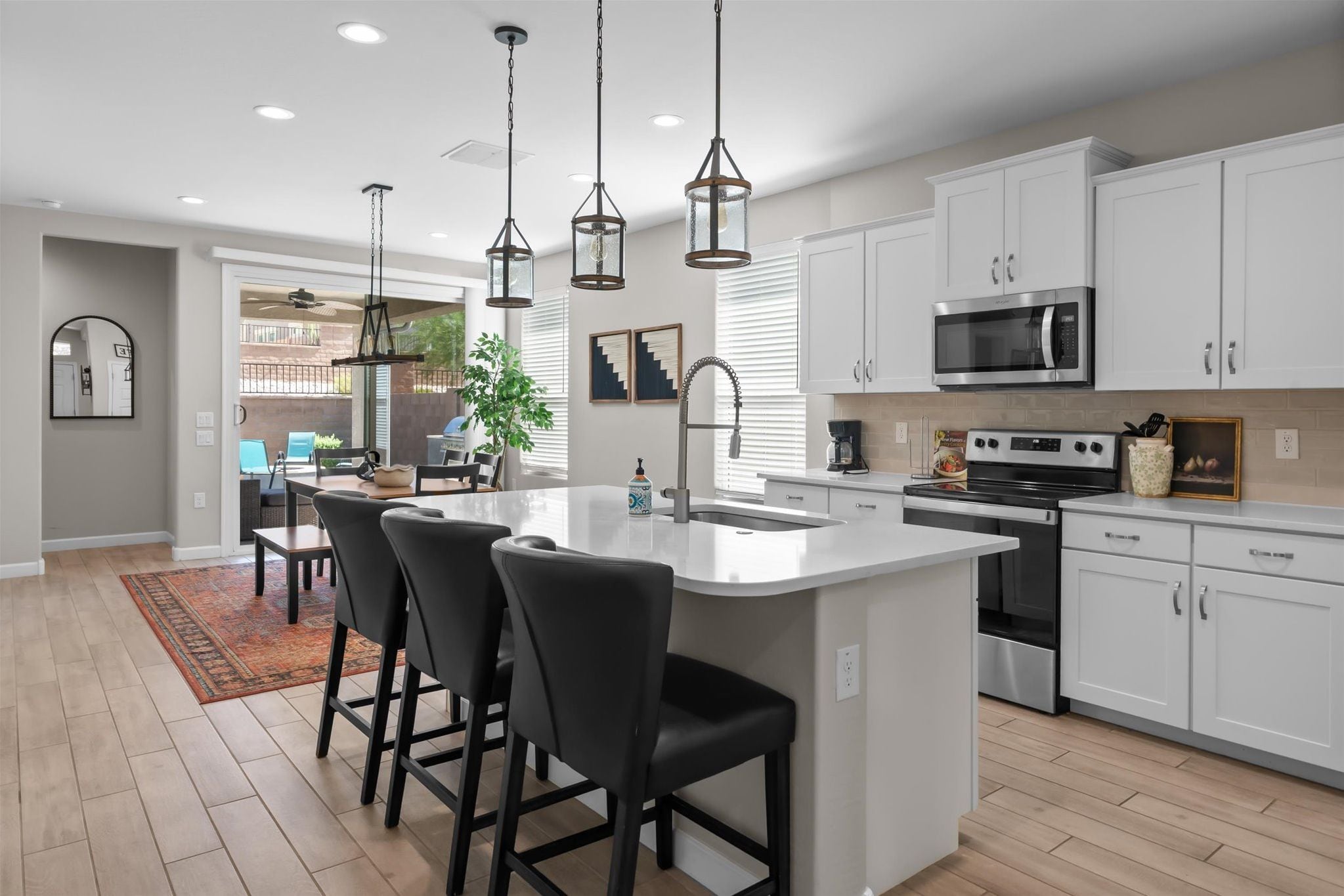 The bright, open kitchen offers a spacious island with seating for three.