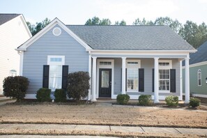 A residential house with a front porch, a black door, and a grey siding exterior. - Gameday Home · Dog-Friendly · Private Lake (Bessemer)