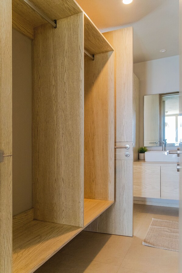 Un baño moderno con muebles de madera, un lavabo y un espejo.