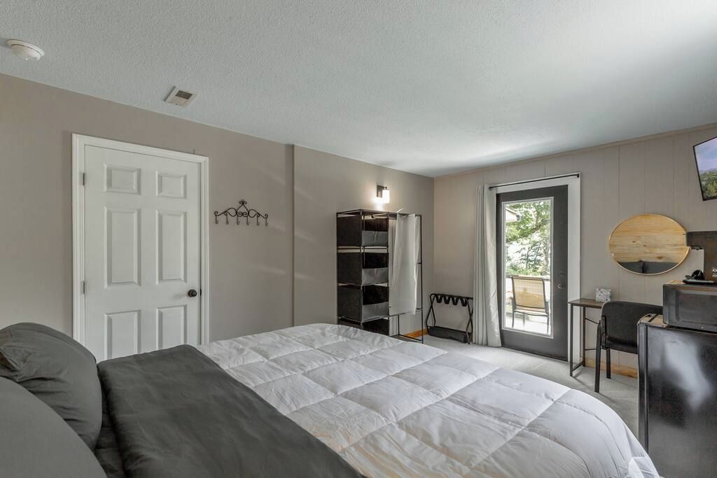 Een slaapkamer met een bed, een kast, een bureau en een stoel.