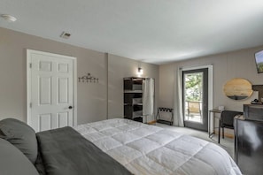 Een slaapkamer met een bed, een kast, een bureau en een stoel.