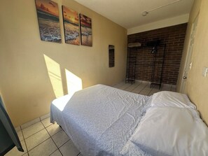 Ein Schlafzimmer mit einem Bett, einer Ziegelwand und einer Tür.