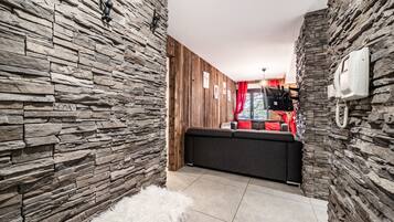 Un intérieur moderne avec des murs en pierre, un canapé et un tapis blanc moelleux.