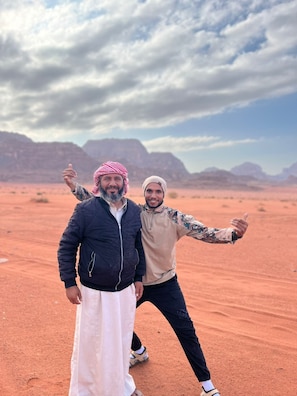 Two individuals in a desert landscape with mountains in the background. - Wadi Rum Sand Story Camp & Tours (Wadi Rum)