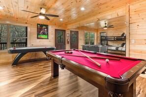 A pool room with two pool tables, ceiling fans, and windows. - Bear Mountain Hideaway~Theater Room~Game Room~Hot-Tub (Sevierville)