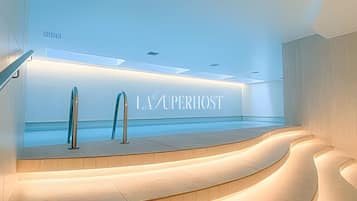 Un interior moderno con un área de piscina, un espacio de descanso curvo y una pared con el texto 'LA SUPERIOST'.